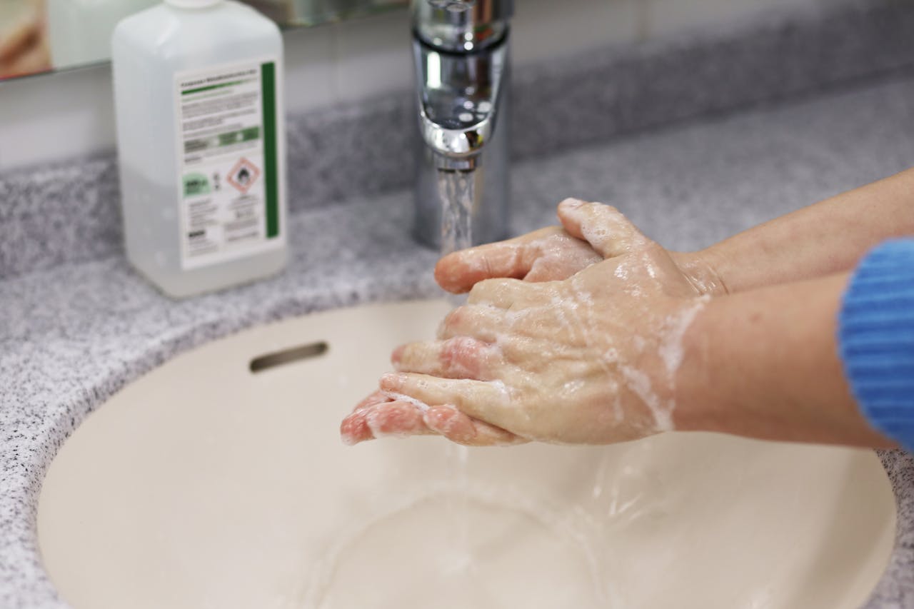 Close-up image of hands washing with soap in a bathroom sink promotes hygiene and cleanliness.